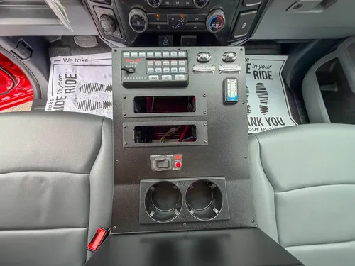 Center console panel with switches, outlets, and cupholders.